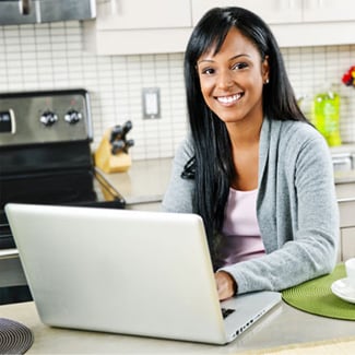 Smiling woman typing on a laptop